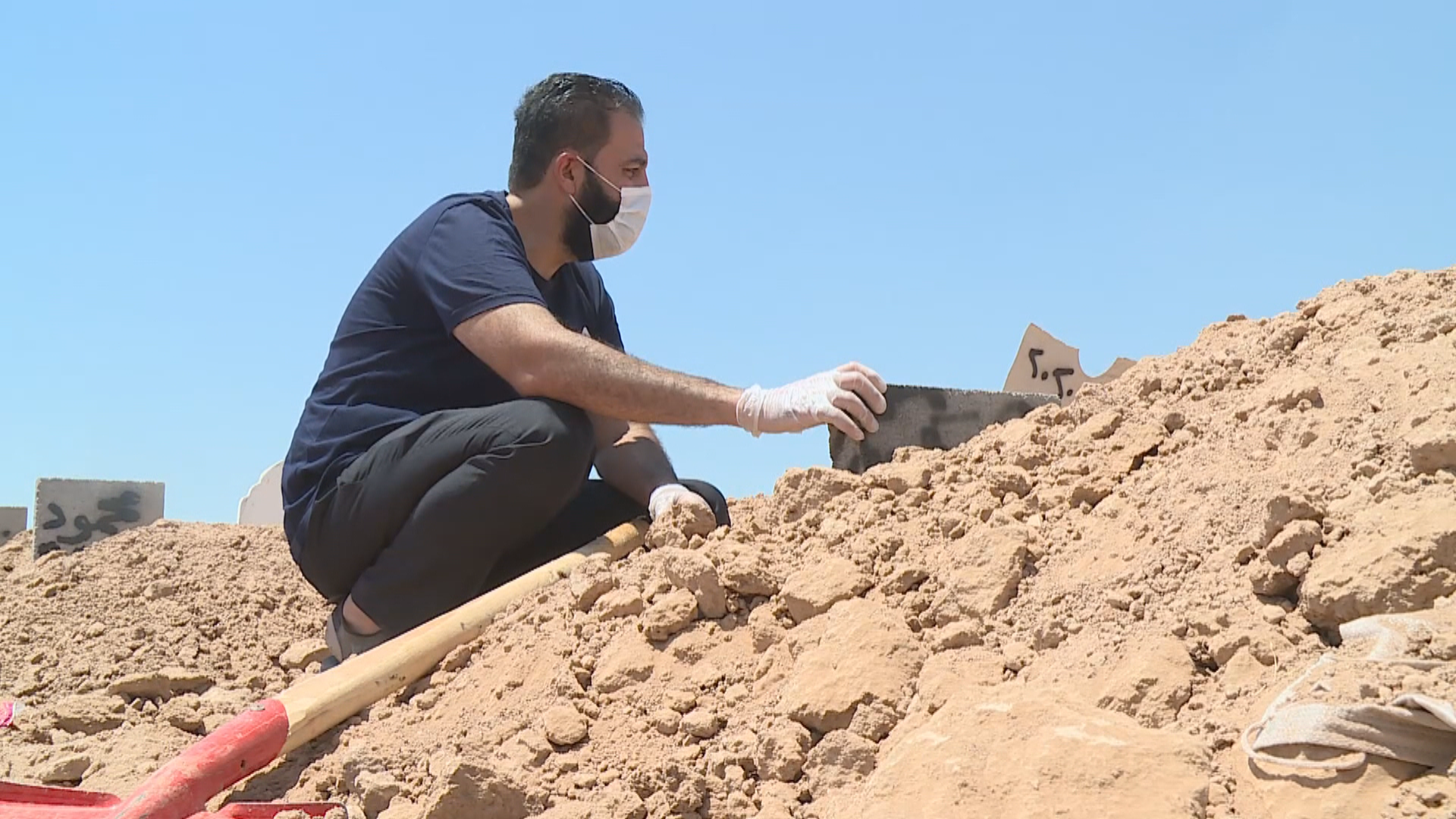 Karime sits by his wife's grave Tuesday. Photo: Rudaw TV Karime sits by his wife's grave Tuesday. Photo: Rudaw TV